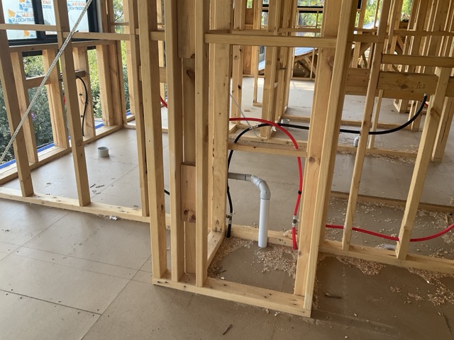 Cost to complete report photo showing internal rough-in and timber framing stage.