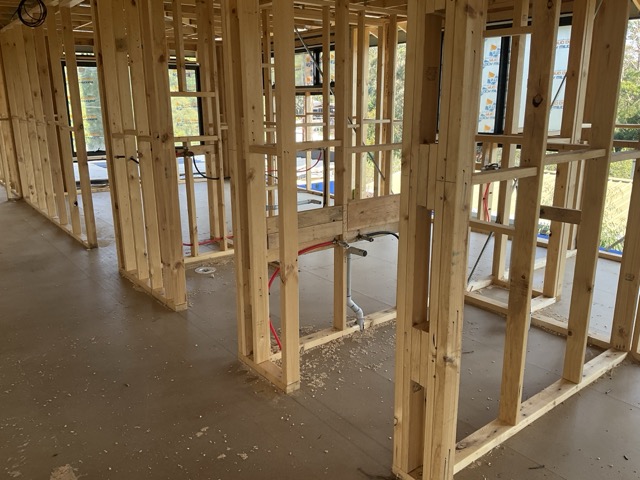 Progress claim report photo showing internal wall framing during residential construction.